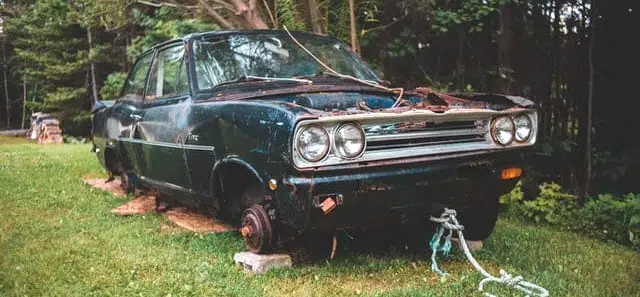 Abandoned car sitting unused in a field