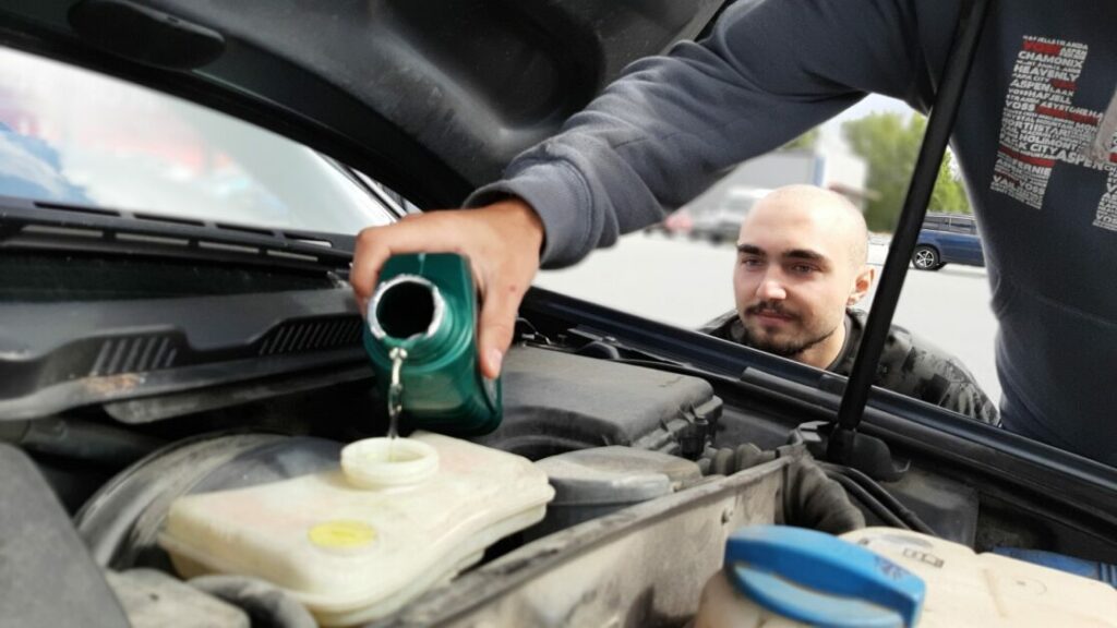 man filling up the brake fluid reservoir
